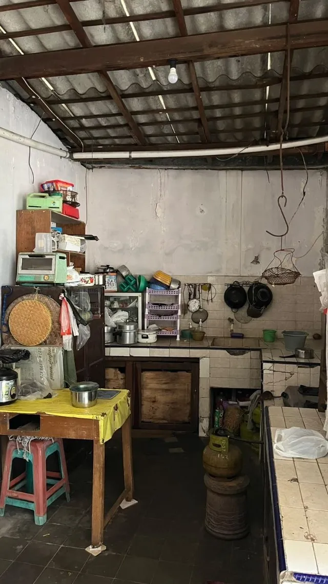 Sebelum: dapur dengan meja kayu, rak, dan meja keramik yang penuh peralatan masak dan barang