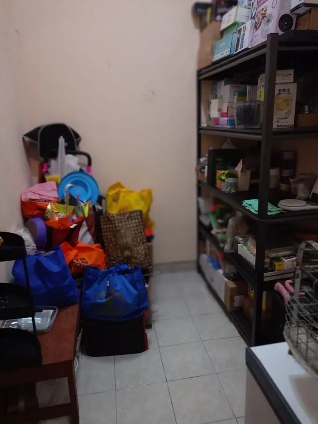 Sesudah: lantai gudang lega, barang tertata di rak dan dikelompokkan dalam tas